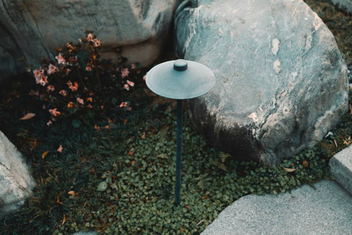 Professional garden landscape lighting installation with layered uplights and path markers